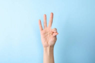 Woman showing number nine on color background, closeup. Sign language clipart