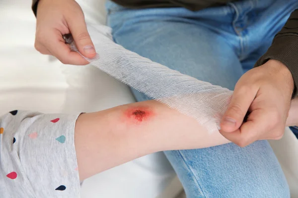 Father Applying Bandage Daughter Injured Knee Home Closeup First Aid — Stock Photo, Image