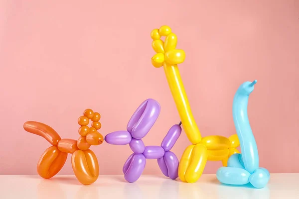 Φιγούρες Από Μοντελοποίηση Μπαλόνια Στο Τραπέζι Κατά Χρώμα Φόντου — Φωτογραφία Αρχείου