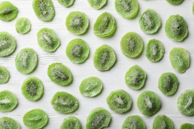 Dilim kivi, düz ahşap arka plan üzerinde yatıyordu. Kurutulmuş meyve sağlıklı gıda olarak