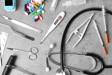Gri arka plan üzerinde farklı tıbbi nesnelerle düz yatıyordu kompozisyon