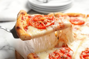 Sıcak peynir pizza Margherita masada, closeup dilim alıyor