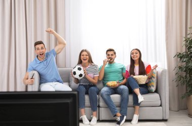 Grup insan birlikte Divan oturma odasında Tv izliyor. Metin için yer