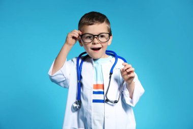 Doktor ceket renk arka plan üzerinde stetoskop ile şirin çocuk