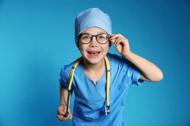 Doktor tek tip renk arka plan üzerinde stetoskop ile şirin küçük çocuk