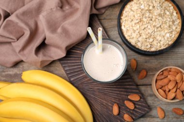 Sağlıklı protein içeceği ve malzemeler ahşap arka plan üzerinde düz yatıyordu kompozisyonu