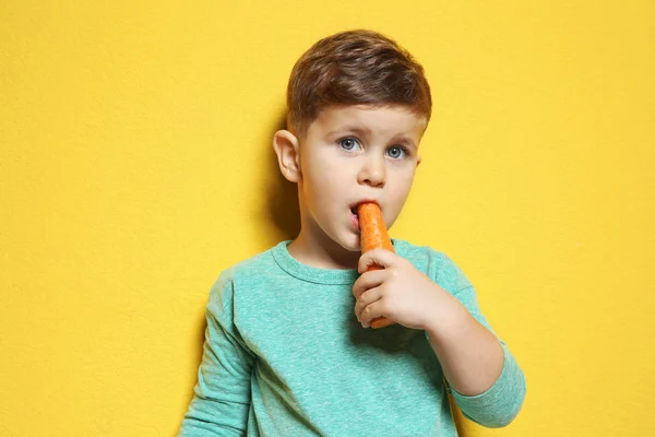 Очаровательный Маленький Мальчик Ест Морковку Цветном Фоне — стоковое фото