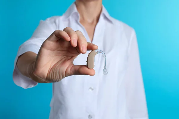 Médico Femenino Sosteniendo Audífono Sobre Fondo Color Primer Plano Objeto — Foto de Stock