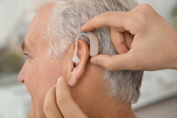 Young Man Putting Hearing Aid Father Ear Indoors Closeup — Stock Photo, Image