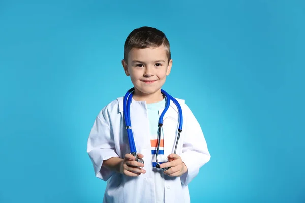 Lindo Niño Con Abrigo Médico Con Estetoscopio Sobre Fondo Color — Foto de Stock
