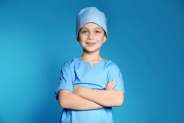 可爱的小孩在医生制服在颜色背景 — 图库照片