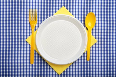 Tablo ayarı ekose kumaş, düz plastik dishware ile yatıyordu