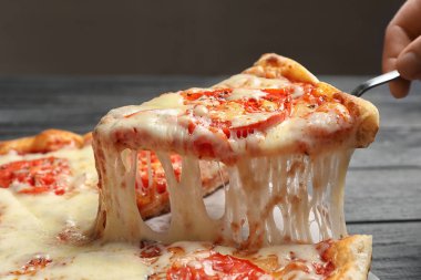 Kadın alarak dilim sıcak peynir pizza Margherita masada, portre
