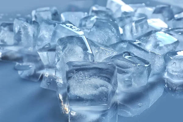 Pile of ice cubes on color background, closeup