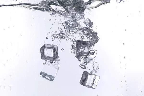 Eiswürfel Die Vor Weißem Hintergrund Ins Wasser Fallen — Stockfoto
