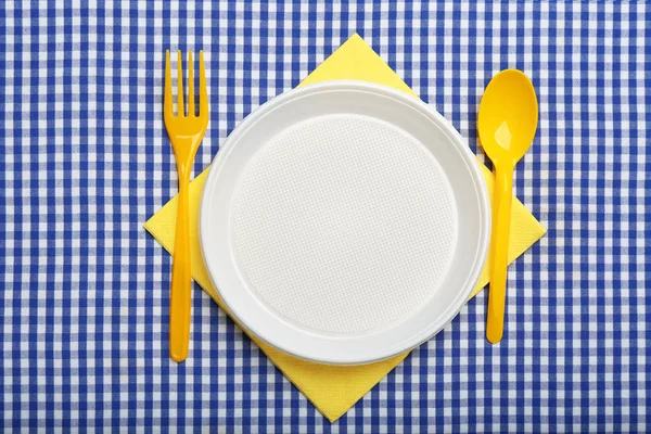 チェック柄のファブリック フラットにプラスチック食器とテーブルの設定レイアウト — ストック写真