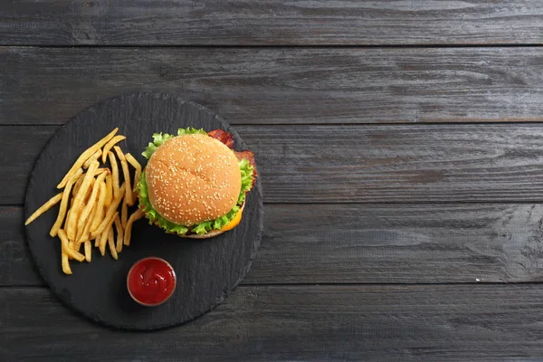 おいしいハンバーガーとフライド ポテト木製の背景 上面にスレート板 テキストのためのスペース — ストック写真