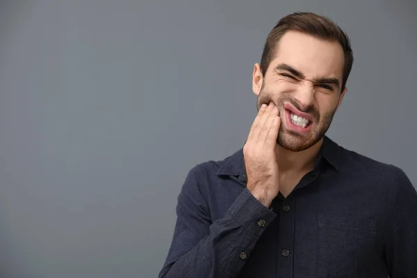 Jovem Sofrendo Dor Dente Forte Fundo Cinza Espaço Para Texto — Fotografia de Stock