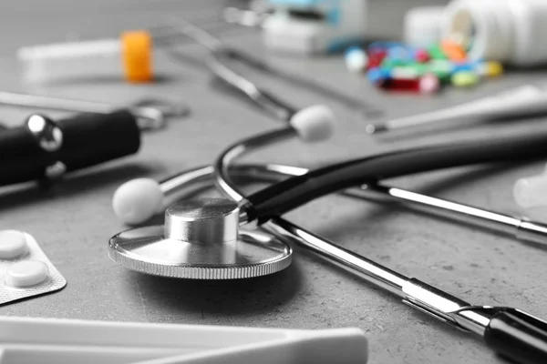 Stethoskop Und Verschiedene Medizinische Gegenstände Auf Grauem Tisch Nahaufnahme — Stockfoto