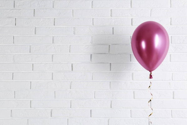 Bright balloon near brick wall, space for text. Party time