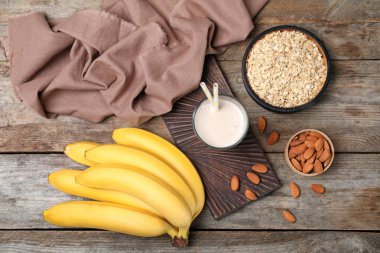 Sağlıklı protein içeceği ve malzemeler ahşap arka plan üzerinde düz yatıyordu kompozisyonu