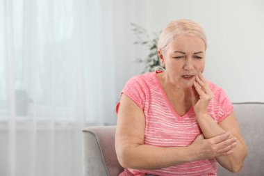 Üst düzey kadın mutfakta, closeup diz ağrısı muzdarip. Metin için yer