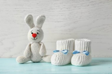 El yapımı bebek patiği ve ahşap arka plan karşı masada doldurulmuş tavşan