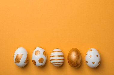 Geleneksel Paskalya yumurtaları kümesi renk arka plan, üstten görünüm üzerinde altın boya ile dekore edilmiştir. Metin için yer