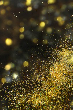 Parlak altın glitter üzerinde bokeh etkisi ile arka plan bulanık. Metin için yer