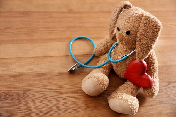 Spielzeughase Stethoskop Herz Und Platz Für Text Auf Holzgrund Kinderarzt — Stockfoto