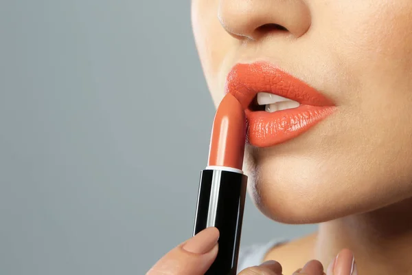 Mujer Joven Aplicando Lápiz Labial Hermoso Sobre Fondo Gris Primer — Foto de Stock