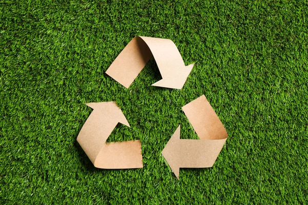 Recycling Symbool Gesneden Uit Kraftpapier Groen Gras Bovenaanzicht — Stockfoto