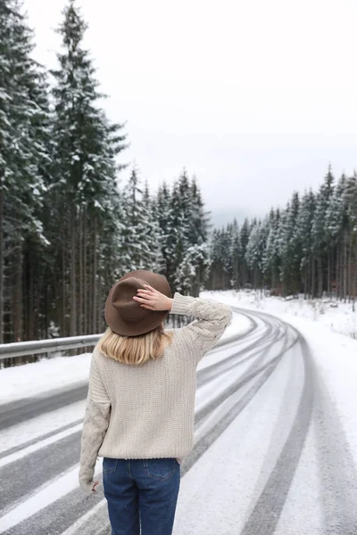年轻的女人走在雪堆森林附近 — 图库照片