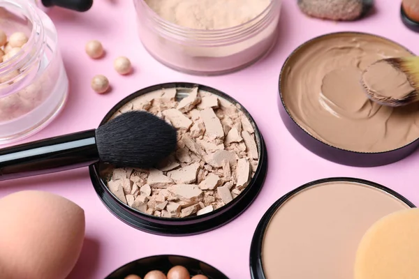 Composition with skin foundation, powder and beauty accessories on color background