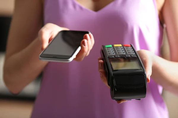 Vrouw Met Behulp Van Moderne Betaalterminal Met Mobiele Telefoon Binnenshuis — Stockfoto