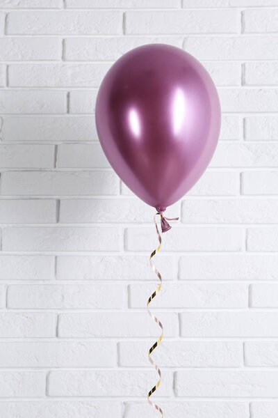 Bright balloon near brick wall. Party time