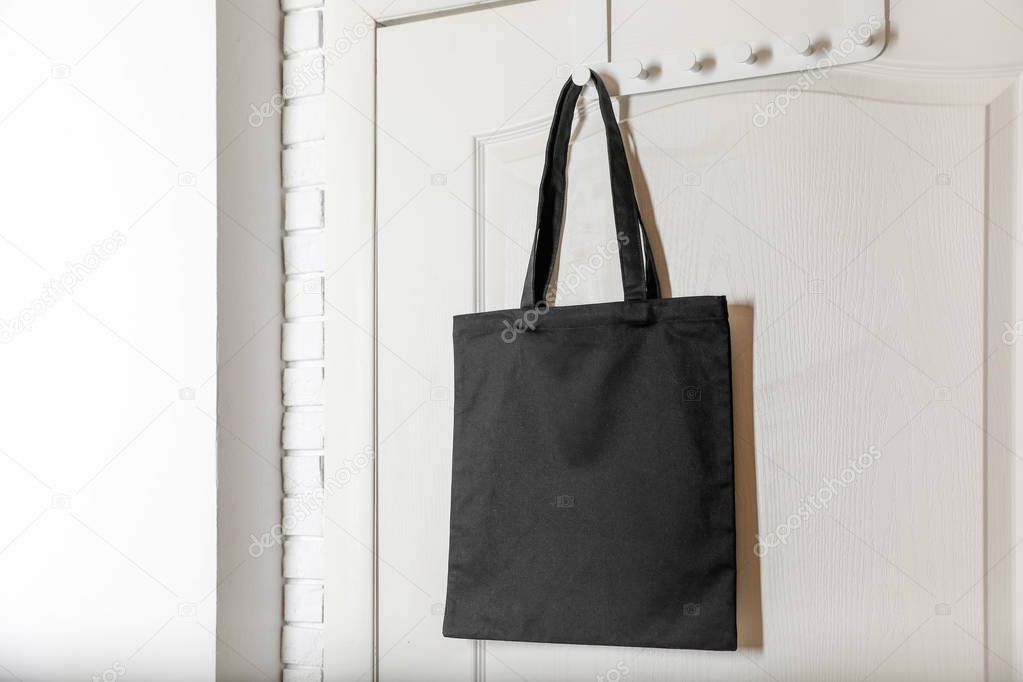 Eco tote bag hanging on door. Space for design