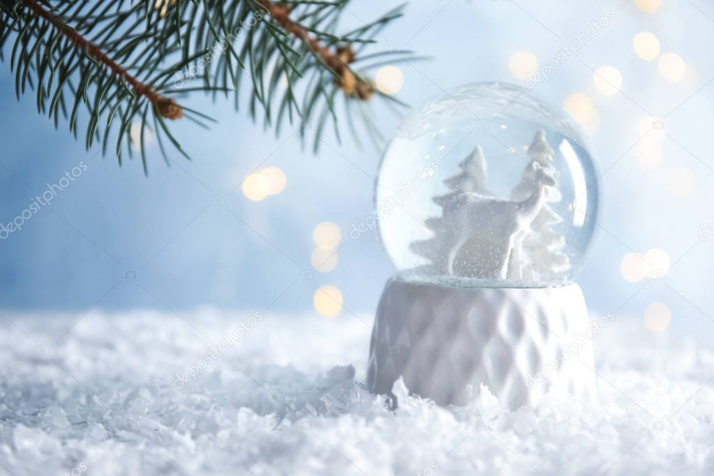 Glass globe with deer and trees on artificial snow. Space for text
