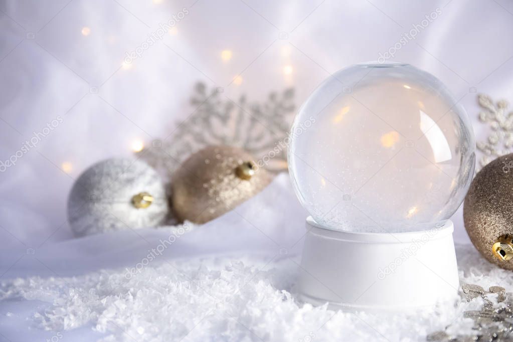 Magical empty snow globe with Christmas decorations on white fabric. Space for text
