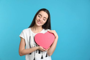 Renk arka plan üzerinde dekoratif kalpli güzel genç kadın portresi