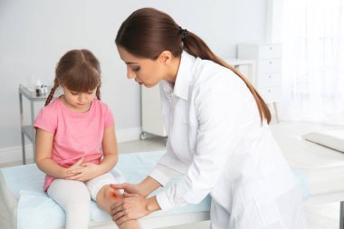 Kadın doktor küçük kızın inceleyerek klinik bacağından yaralandı. İlk yardım