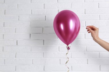 Genç kadın tuğla duvar, metin için yer yakınındaki parlak balon piercing
