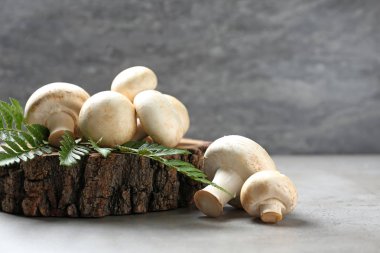 Ahşap güdük ve masada yaprak taze champignon mantar