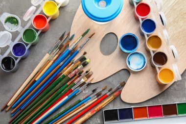 Görünümü farklı boyalar, fırçalar ve palet gri arka plan üzerinde top