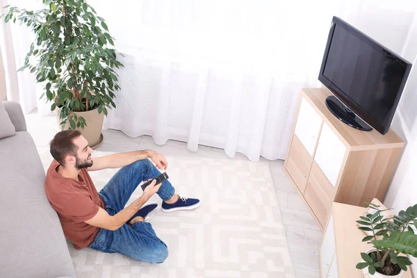 Beau Jeune Homme Assis Sur Sol Regardant Télévision Maison — Photo