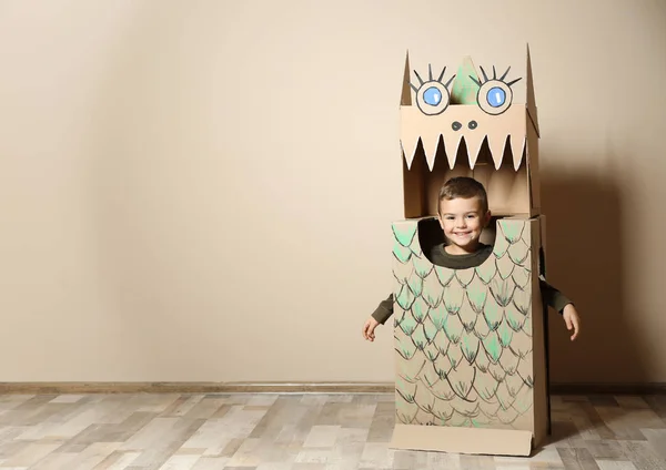 Anak Kecil Yang Lucu Dalam Kostum Kardus Dinosaurus Dekat Dinding — Stok Foto