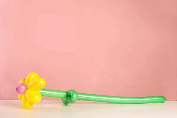 Λουλούδι Σχήμα Κατασκευασμένο Από Μοντελοποίηση Μπαλόνι Στο Τραπέζι Ενάντια Έγχρωμο — Φωτογραφία Αρχείου