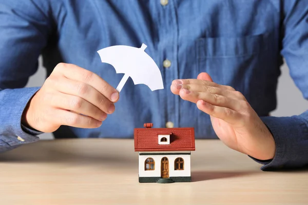 Мужчина Прикрывающий Модель Дома Зонтиком Столом Крупным Планом Страхование — стоковое фото