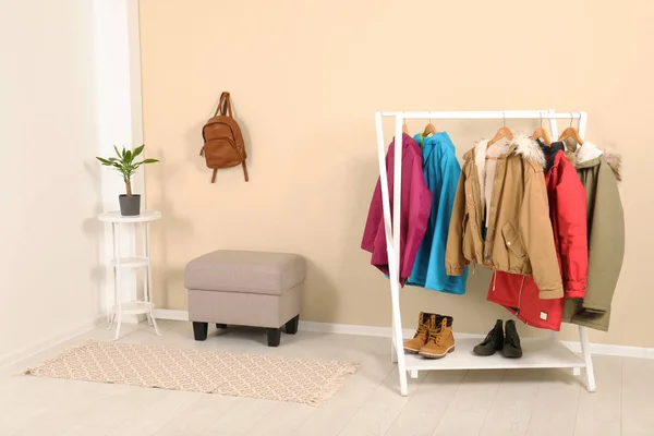 Modern hallway interior with mirror and clothes on hanger stand