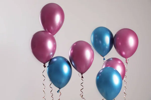 Globos Brillantes Con Cintas Volando Sobre Fondo Claro —  Fotos de Stock